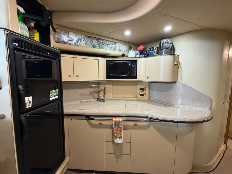 Slide: The Image of The galley of a 1999 Sea Ray 380 Sundancer with a fridge, microwave, and sink. - 14