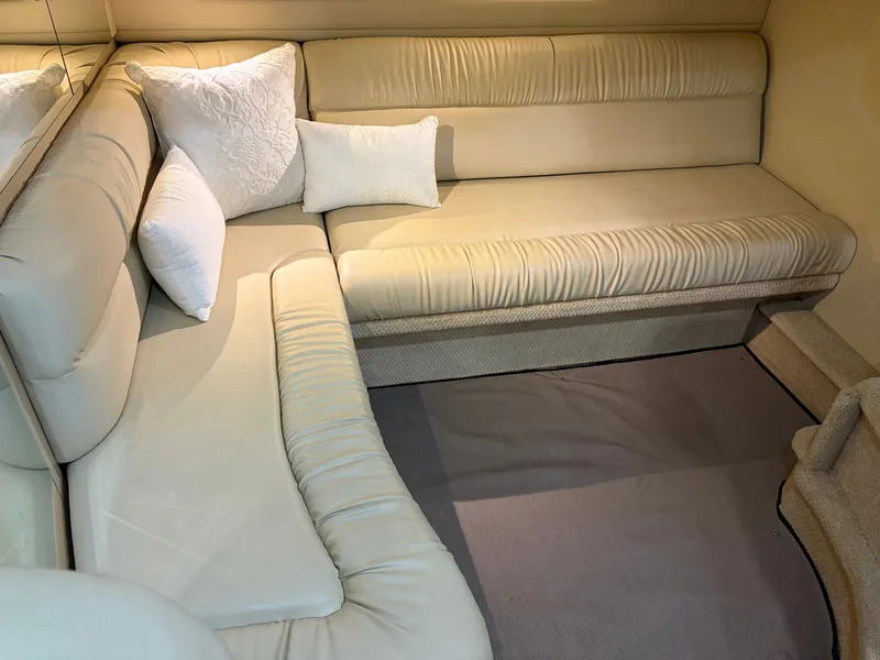 Slide: The Image of Interior of a 1999 Sea Ray 380 Sundancer with beige upholstery and white pillows. - 16