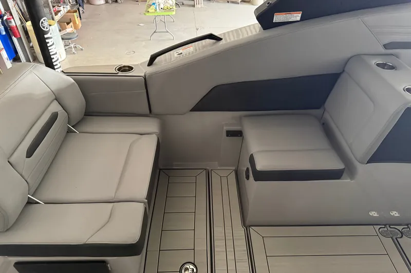 Slide: The Image of Interior seating of 2026 Yamaha Boats 295XD, featuring sleek gray upholstery and cup holders. - 7