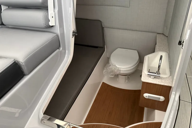 Slide: The Image of Interior of 2026 Yamaha Boats 295XD featuring a compact bathroom with toilet and sink. - 15