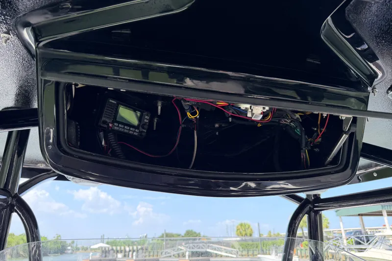 Slide: The Image of Open electronics compartment on 2009 Century 3200 Center Console boat, showing wiring and equipment. - 49