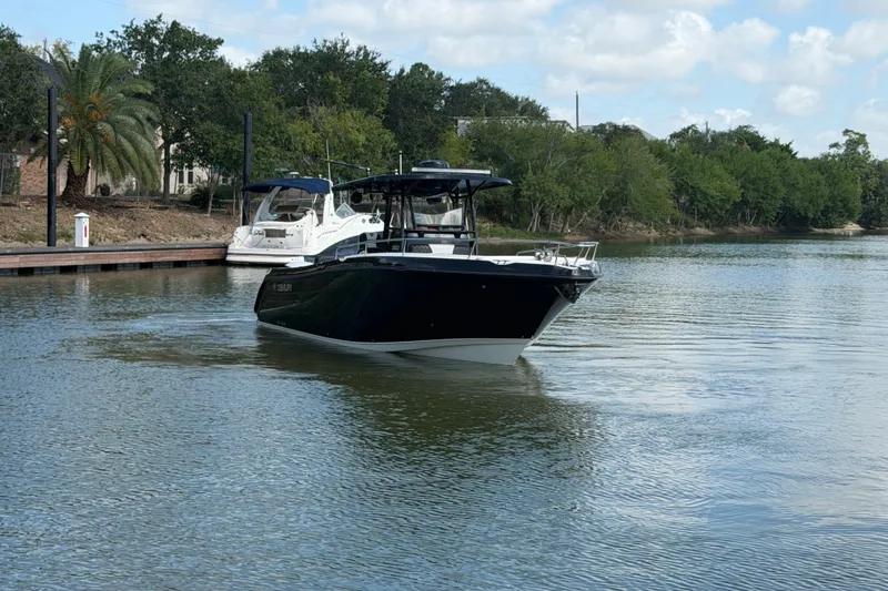 Slide: The Image of 2009 Century 3200 Center Console boat on a calm river with lush greenery. - 7