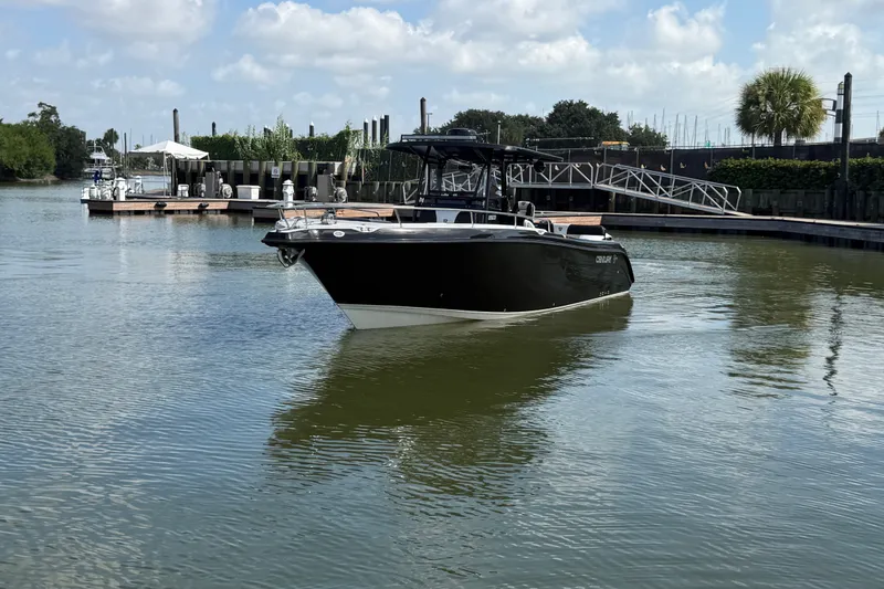 Slide: The Image of 2009 Century 3200 Center Console boat docked in a serene marina setting. - 1