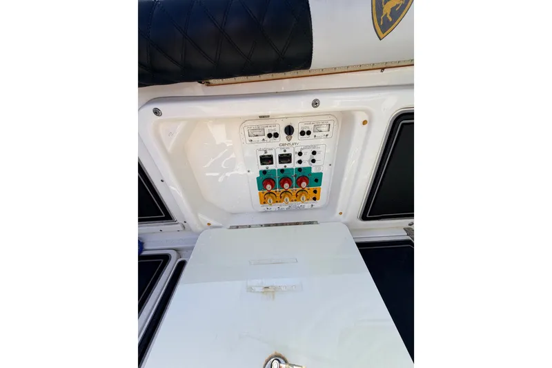 Slide: The Image of Control panel of a 2009 Century 3200 Center Console boat, featuring various switches and dials. - 56