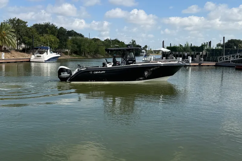 Slide: The Image of 2009 Century 3200 Center Console boat on calm water near a marina. - 2