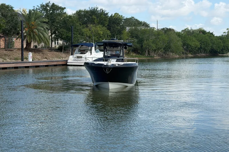 Slide: The Image of 2009 Century 3200 Center Console boat cruising on a calm river near a dock. - 8