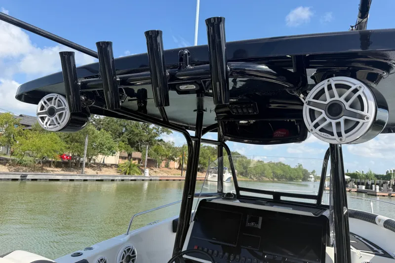 Slide: The Image of 2009 Century 3200 Center Console boat with speakers and rod holders on a sunny day. - 24