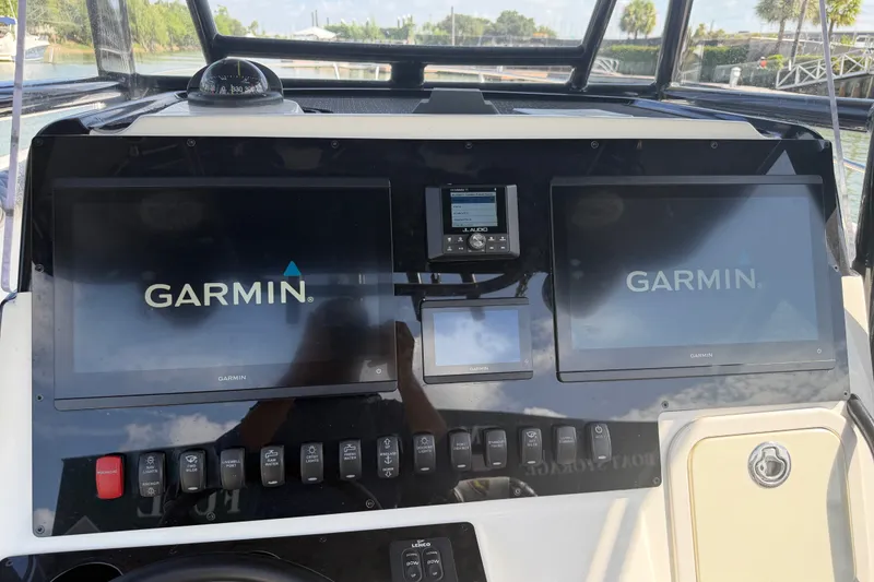 Slide: The Image of Century 3200 Center Console 2009 boat dashboard with Garmin navigation displays. - 29