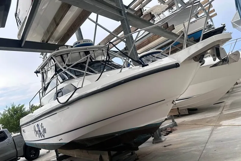 Slide: The Image of 2003 Boston Whaler 295 Conquest boat stored on a rack in a marina. - 3