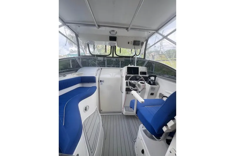 Slide: The Image of Interior of 2003 Boston Whaler 295 Conquest boat with blue seating and steering console. - 6