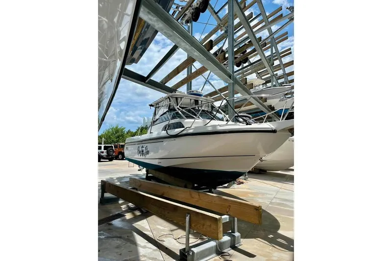 Slide: The Image of 2003 Boston Whaler 295 Conquest boat on dry dock, ready for maintenance. - 4