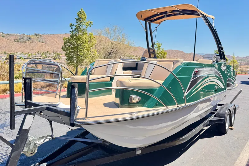 Slide: The Image of 2019 Razor 258 pf boat on trailer, green and white design, parked outdoors. - 3