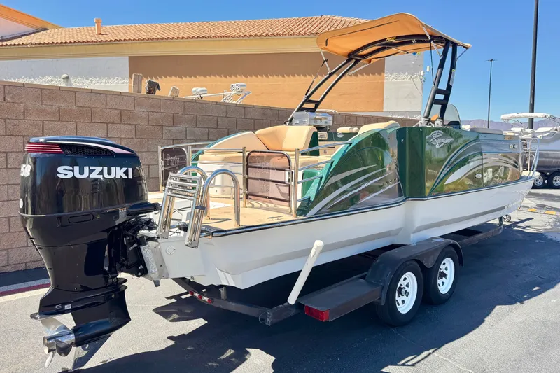 Slide: The Image of 2019 Razor 258 pf boat with Suzuki engine on trailer, parked outdoors. - 5