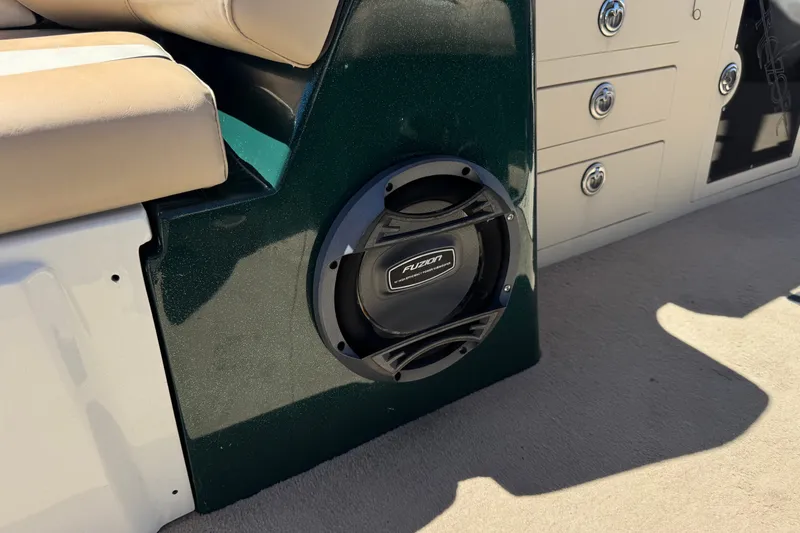 Slide: The Image of Boat interior with Fusion speaker, beige seating, and storage compartments. Razor 258 pf, 2019 model. - 27