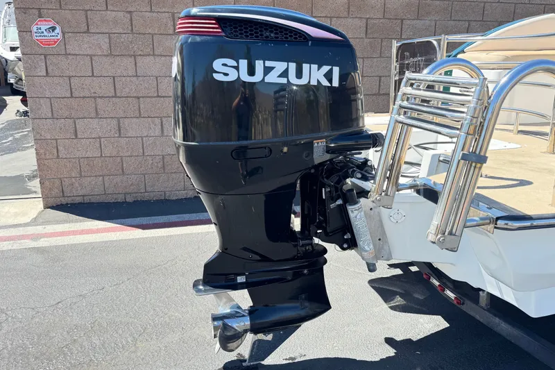 Slide: The Image of Suzuki outboard motor on a Razor 258 pf boat, 2019 model, parked outdoors. - 6