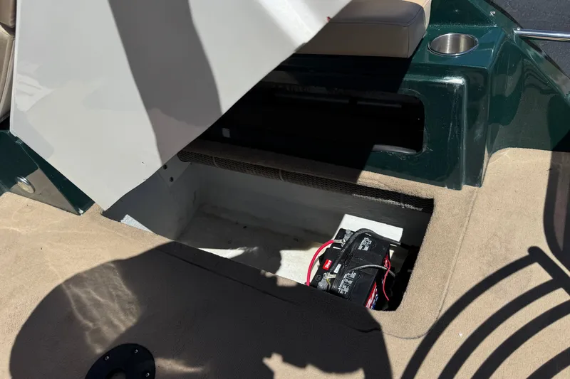 Slide: The Image of Open storage compartment in a 2019 Razor 258 pf boat, revealing a battery inside. - 26