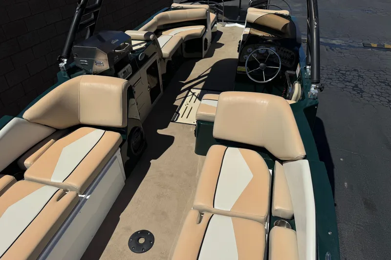 Slide: The Image of Interior of a 2019 Razor 258 pf boat with beige seating and steering wheel. - 10