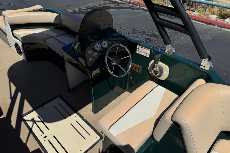 Slide: The Image of Interior of a 2019 Razor 258 pf boat with beige seating and steering console. - 28