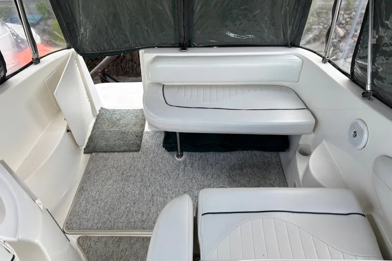 Slide: The Image of Interior of a 2003 Maxum 2500 SCR boat with white seating and carpeted floor. - 1