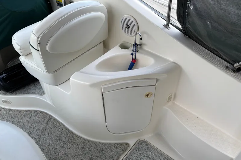 Slide: The Image of 2003 Maxum 2500 SCR boat interior with white seating and sink area. - 2