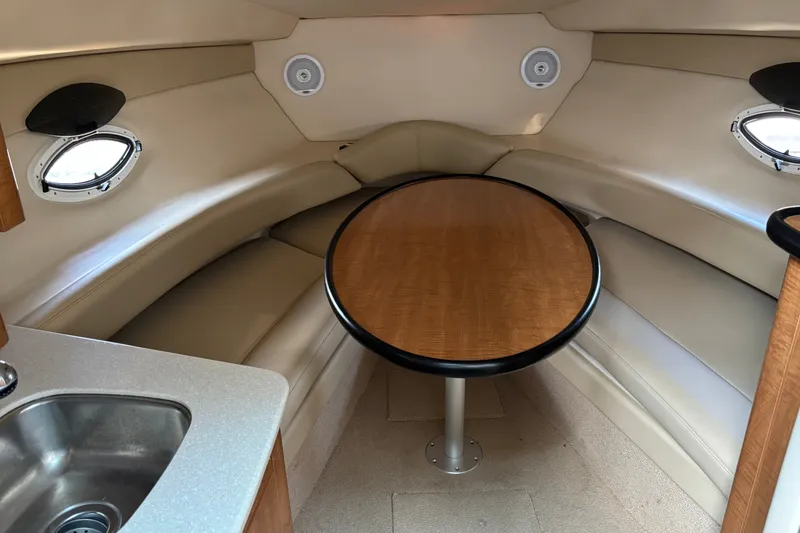 Slide: The Image of 2003 Maxum 2500 SCR cabin interior with table, seating, and portholes. - 12