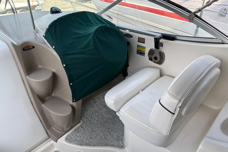 Slide: The Image of 2003 Maxum 2500 SCR boat interior with white seating and green cover. - 5