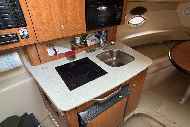 Slide: The Image of 2003 Maxum 2500 SCR boat interior with kitchenette, sink, and microwave. - 11
