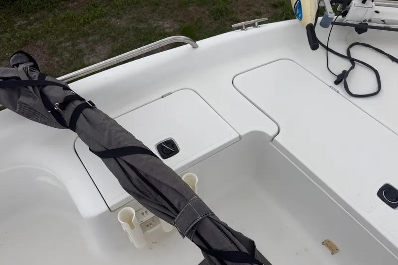 Slide: The Image of 2000 Polar 2100 Center Console boat deck with storage compartments and fishing rod holders. - 19
