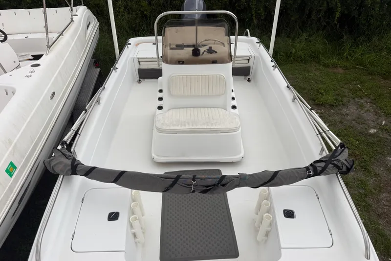 Slide: The Image of 2000 Polar 2100 Center Console boat with seating and steering console, docked on grass. - 23