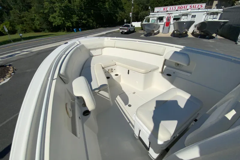 Slide: The Image of 2014 Sailfish 290 CC boat interior with seating, displayed at a boat sales lot. - 23