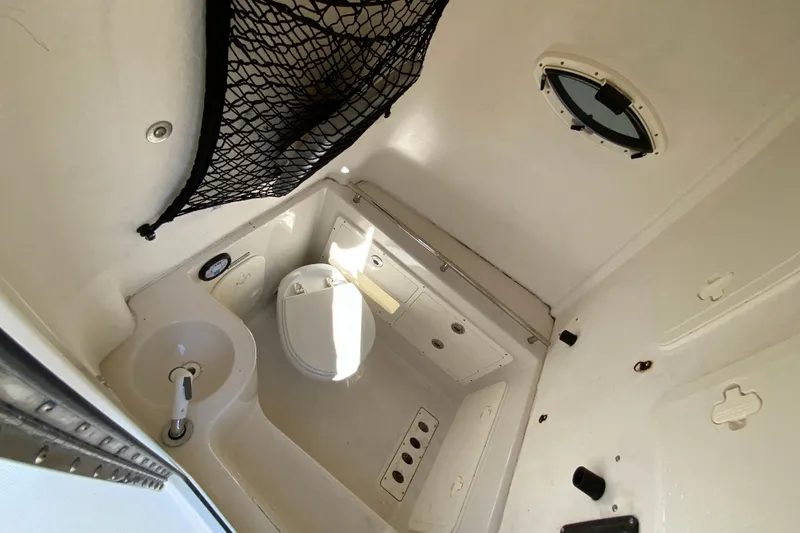 Slide: The Image of Interior of 2014 Sailfish 290 CC boat bathroom with sink and toilet. - 31