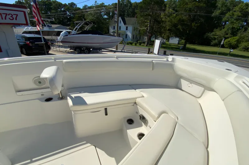 Slide: The Image of 2014 Sailfish 290 CC boat interior with cushioned seating and cup holders. - 25
