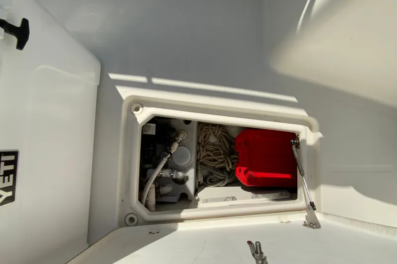 Slide: The Image of Storage compartment on 2014 Sailfish 290 CC boat with ropes and red container. - 29