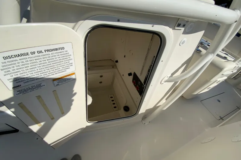 Slide: The Image of Open hatch on 2014 Sailfish 290 CC boat, showing interior compartment and safety warning. - 30