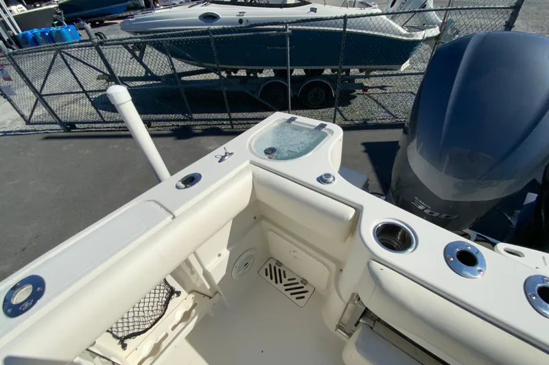 Slide: The Image of 2014 Sailfish 290 CC boat interior with fishing rod holders and engine view. - 14