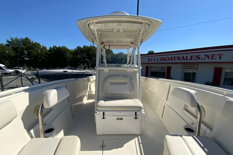 Slide: The Image of 2014 Sailfish 290 CC boat interior with seating and helm, parked at dealership. - 27