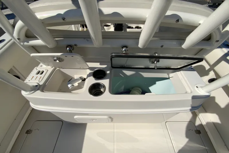 Slide: The Image of 2014 Sailfish 290 CC boat interior with open storage compartments and cup holders. - 34