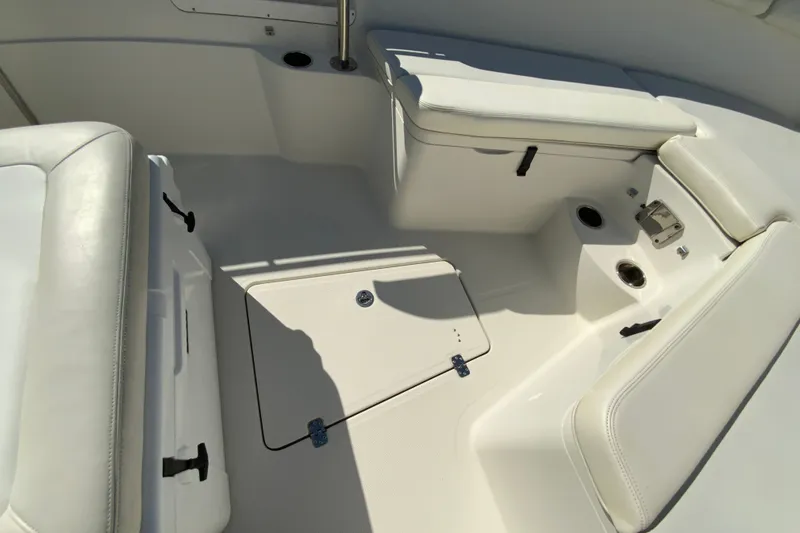 Slide: The Image of 2014 Sailfish 290 CC boat interior with white seating and storage compartments. - 28