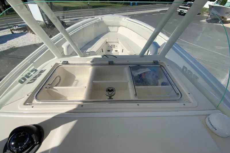 Slide: The Image of 2014 Sailfish 290 CC boat deck with storage compartments and Garmin equipment. - 20