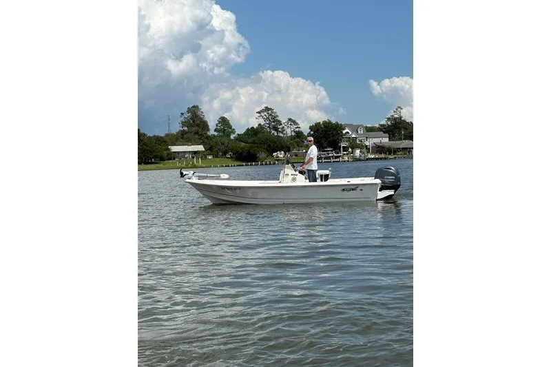 Slide: The Image of Bulls Bay 2000 boat on calm water, 2026 model, with person onboard. - 2
