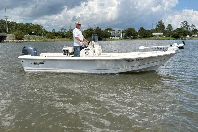 The Image of Man piloting a 2026 Bulls Bay 2000 boat on a calm lake. - 0