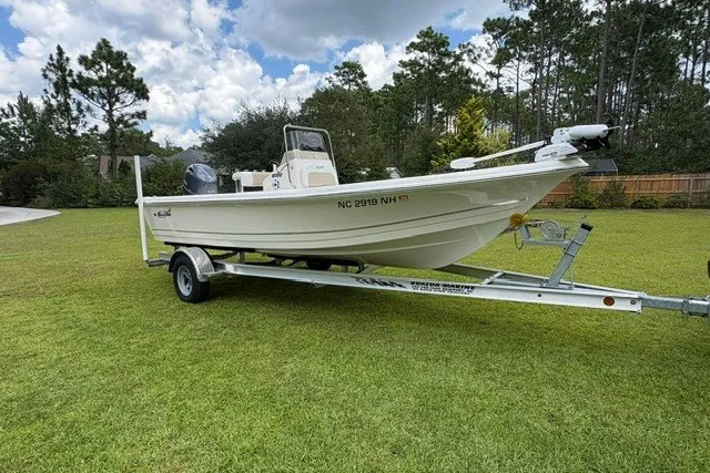 Slide: The Image of 2026 Bulls Bay 2000 boat on trailer, parked on grass with trees in background. - 4