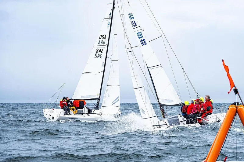 Slide: The Image of Sailboats racing on the ocean, featuring 2013 J Boats J/70 models. - 14