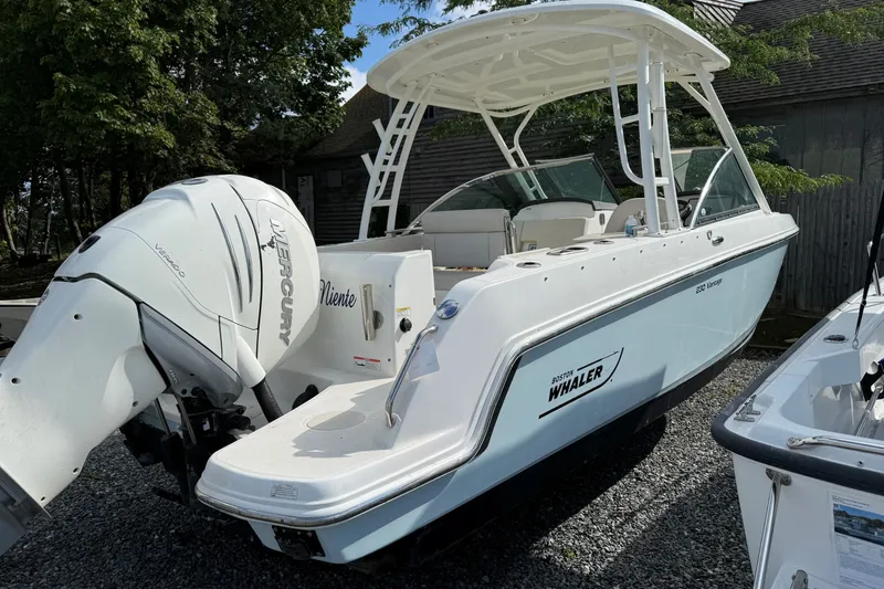 Slide: The Image of 2018 Boston Whaler 230 Vantage boat with Mercury engine, parked outdoors. - 2