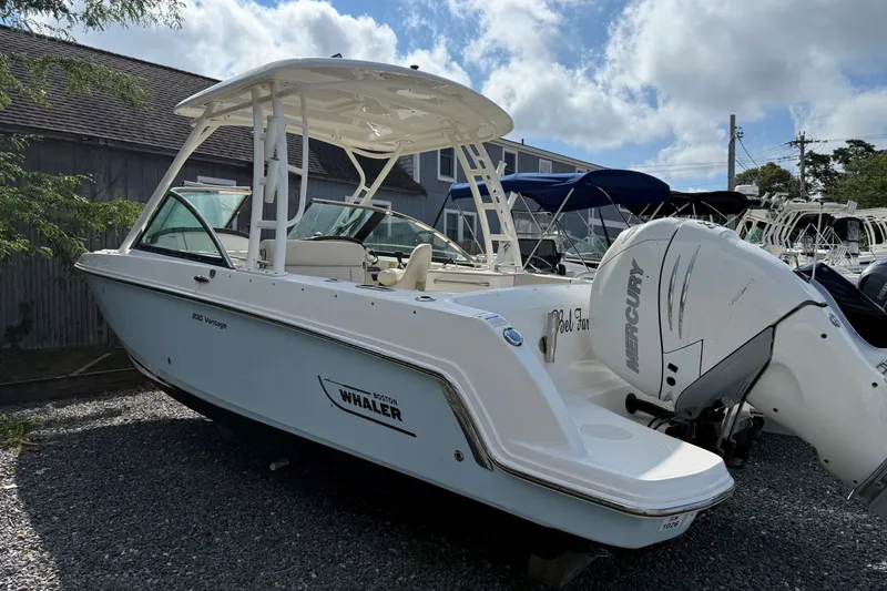 Slide: The Image of 2018 Boston Whaler 230 Vantage boat with Mercury engine, parked outdoors. - 1