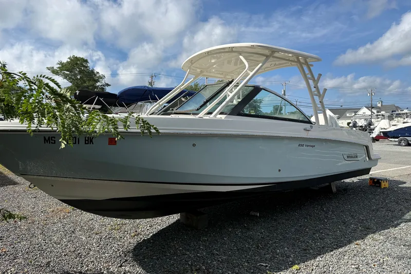 Slide: The Image of 2018 Boston Whaler 230 Vantage boat on gravel lot under blue sky. - 3