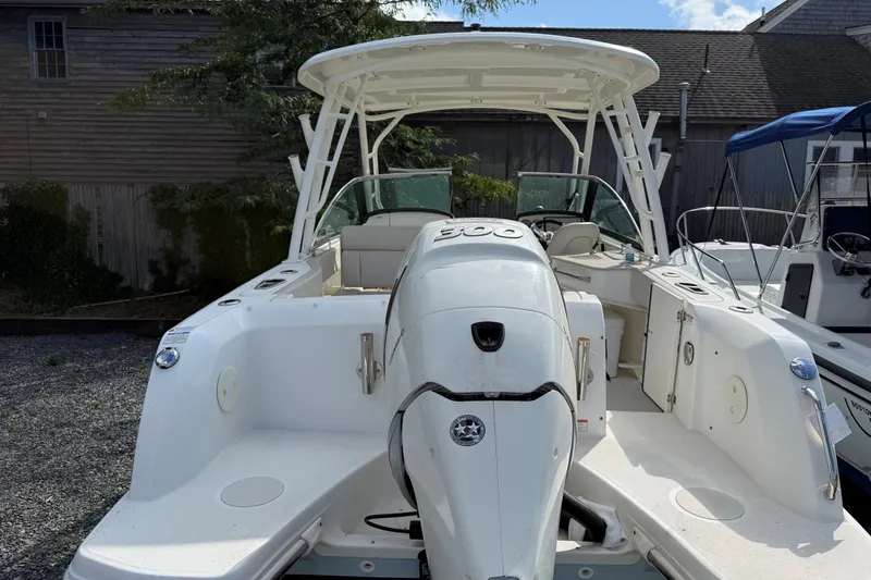 Slide: The Image of 2018 Boston Whaler 230 Vantage boat with outboard motor, docked outdoors. - 11