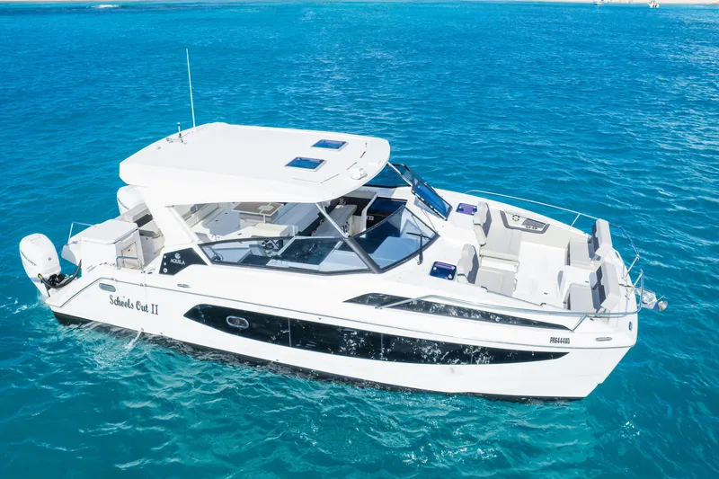 The Image of 2023 Aquila 36 Sport boat cruising on clear blue water. - 0