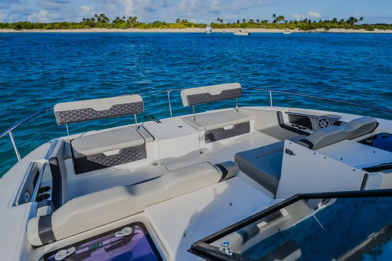 Slide: The Image of 2023 Aquila 36 Sport boat interior with seating, on blue ocean near tropical island. - 39