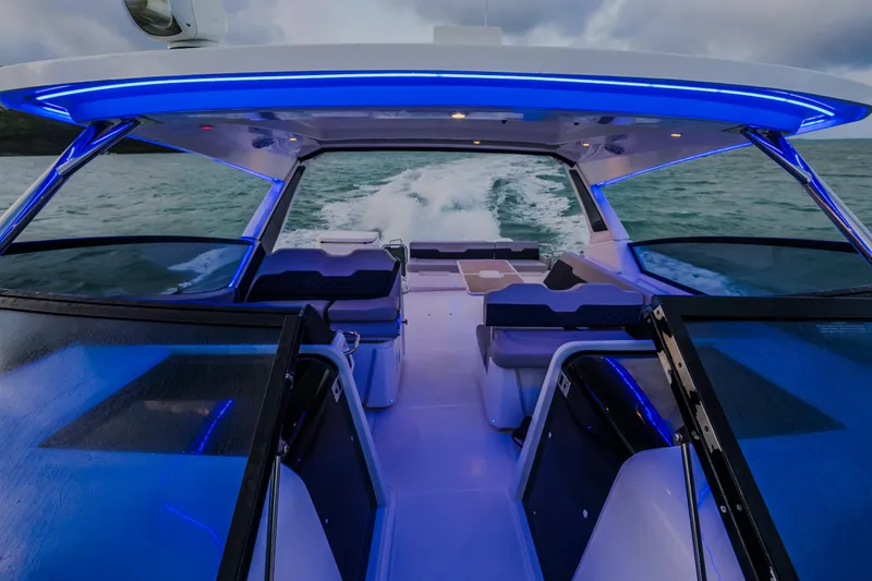 Slide: The Image of 2023 Aquila 36 Sport boat interior with blue LED lighting on the water. - 58